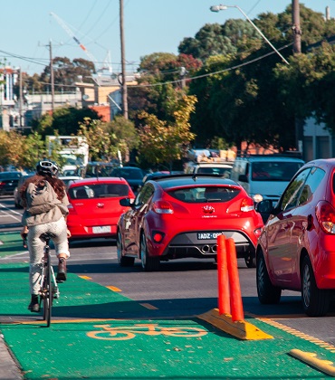 Bike rider on bike lane next to vehicle traffic